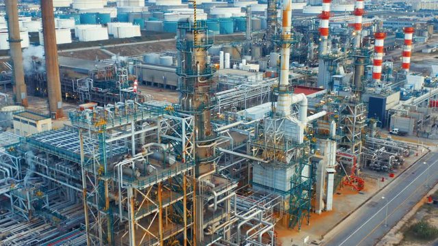Aerial view of petrochemical oil refinery (refining complex). Oil and gas tanks with fuming pipes on the plant (factory)