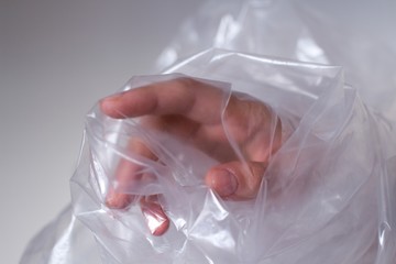 young womans hand covered in transparent air bubble plastic wrap