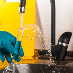 water purification specialist tap water pours into a glass flask.
