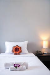 Towel with Orchid on bed decoration in bedroom interior for hotel customer.