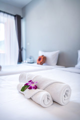 Towel with Orchid on bed decoration in bedroom interior for hotel customer. - obrazy, fototapety, plakaty