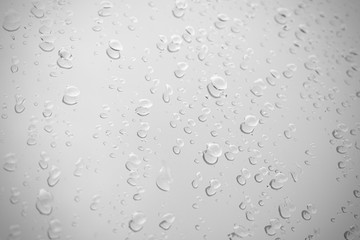 Raindrop water dew drop on glass wet white gray blue background.