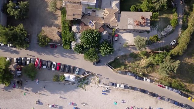 Flying above Mediterranean sea onto beach, top view aerial