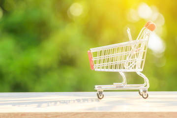 Shopping cart or shopping trolley on green bokeh nature background, Concept of shopping. Copy space...