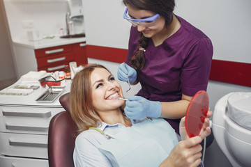 Beautiful lady in the dentist's office. Woman in a purple uniform