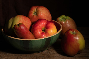 Textured ripe apples and pear on old wood