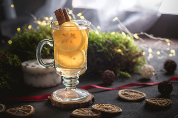 Hot tea with lemon and cinnamon on dark background