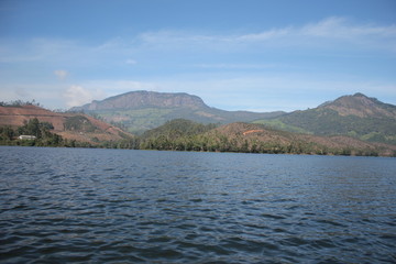 Beautiful landscape of blue-sky with a white clouds and a dry grass fields. Boating in the Ooty Lake, Reflection of blue sky and beautiful clouds in lake Ooty - Tamil Nadu