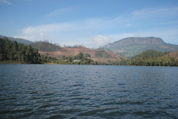 Beautiful landscape of blue-sky with a white clouds and a dry grass fields. Boating in the Ooty Lake, Reflection of blue sky and beautiful clouds in lake Ooty - Tamil Nadu