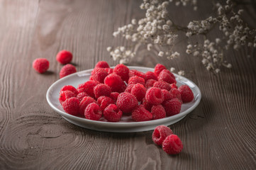 Fresh Raspberries in bowl on wooden table