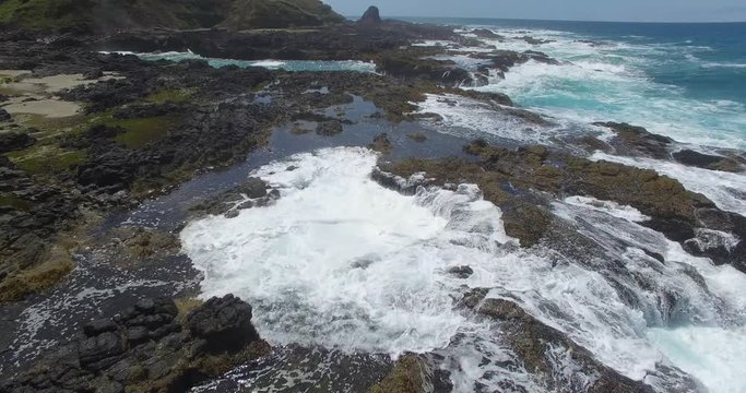 A medium high shot of Thor’s well as a spouting horn blows water in the backdrop of this epic footage capturing the rugged and rocky coastline of Oregon in the United states of America, USA
