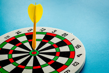 Darts game - simple sport for lesure time. Dartboard and arrows or dart on dark wooden background...