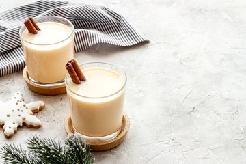 Drink eggnog on grey New Year table decorated with spruce branches and gingerbread copy space