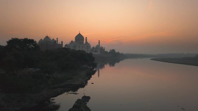 taj mahal in Agra UNESCO site in India view from Yamuna river during sunrise.