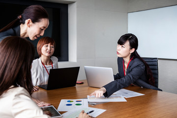 Obraz premium 資料を元に会議を進める女性達