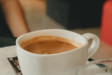 White hot cup of coffee in the cafe. Concept of aroma and relax.
