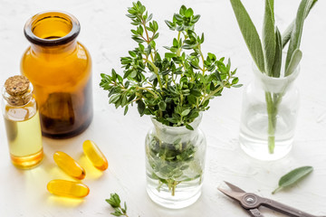 Healing herbs in glasses and medicine on white background