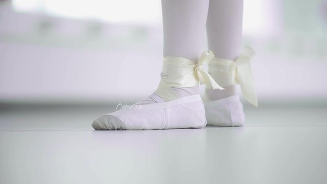 Girl dancer feet in ballet shoes walk ambulate on her toes