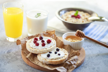Obraz na płótnie Canvas Breakfast. Cereal bread with cottage cheese and berries, with granola and orange juice and natural yogurt. Proper and healthy nutrition.