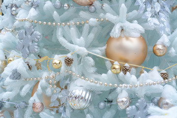 Slightly blurred Christmas background with fir branches, decorative balls and holiday lights.