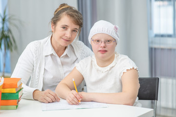 Portrait of the mom and girl with Down Syndrome at school