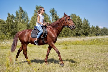 Teenager girl riding a brown horse, horseback riding for people in the park