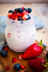 Spring colorful homemade oat porridge with fresh strawberries and blueberries made of buttermilk