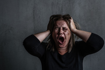 Angry young woman victim of domestic violence and abuse having nervous breakdown screaming. Empty...