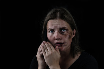 Woman victim of domestic violence and abuse asks for help by phone. Isolated on dark background. Empty space for text
