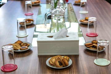Business people sitting on a table for conference with cookies glass and jar of water placed on wooden table