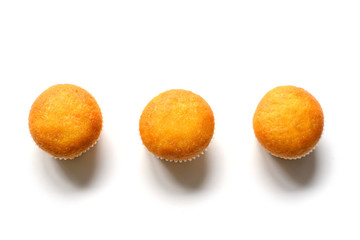 Three cupcakes with different fillings, top view, on a white back