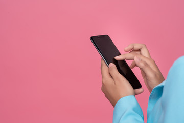 hand of business woman holding phone isolated on pink  background. Free from copy space.
