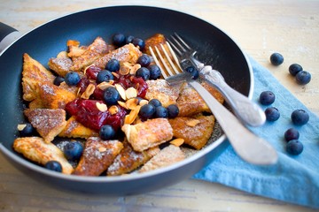 Traditional czech festive easter sweet dish trhanec or austrian Kaiserschmarrn with fresh blueberries, jam and roasted almonds.