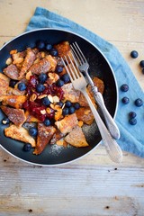 Traditional czech festive easter sweet dish trhanec or austrian Kaiserschmarrn with fresh blueberries, jam and roasted almonds.