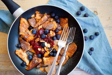 Traditional czech festive easter sweet dish trhanec or austrian Kaiserschmarrn with fresh blueberries, jam and roasted almonds.