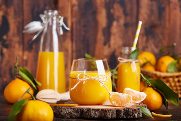 Tangerine orange juice and fresh tangerines. Healthy season organic citrus beverage. 
