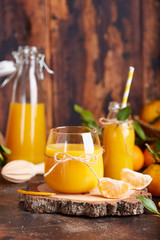 Tangerine orange juice and fresh tangerines. Healthy season organic citrus beverage. 