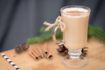 Chocolate Martini Cocktail or eggnog with cinnamon and chocolate in glass for Christmas on mahogany background. Homemade festive cocktail for winter holidays.Close up.