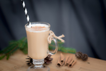 Chocolate Martini Cocktail or eggnog with cinnamon and chocolate in glass for Christmas on mahogany background. Homemade festive cocktail for winter holidays.Close up.