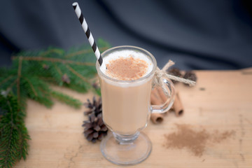 Chocolate Martini Cocktail or eggnog with cinnamon and chocolate in glass for Christmas on mahogany background. Homemade festive cocktail for winter holidays.Close up.