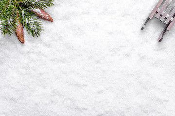 Christmas background with snow, sleigh, and christmas pine branch, composition flat lay, top view