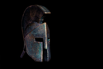Ancient Spartan bronze helmet on black background
