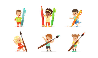 Fototapeta premium Cute Young Children Holding Big Pencils and Pens