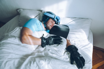 man in bed with snowboard ski googles and helmet