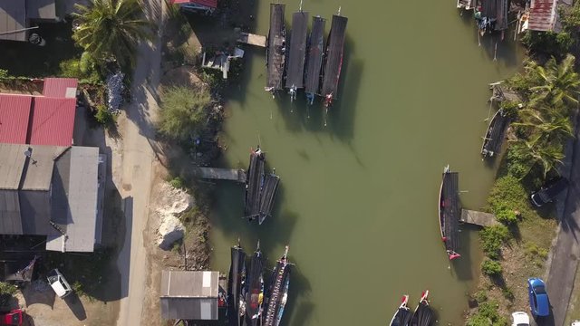 Aerial view of fisherman village with boats dock at the river estuary nearby.