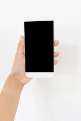 Female hand holding a white cell phone with a black screen at an isolated background.