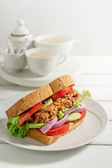 sandwich with fish and fresh vegetables on dish