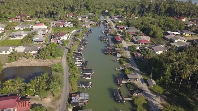 Aerial view of fisherman village with boats dock at the river estuary nearby.