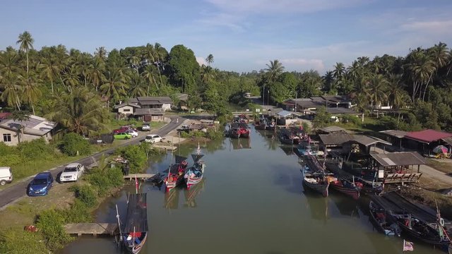 Aerial view of fisherman village with boats dock at the river estuary nearby.