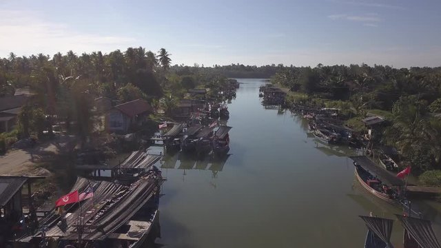 Aerial view of fisherman village with boats dock at the river estuary nearby.